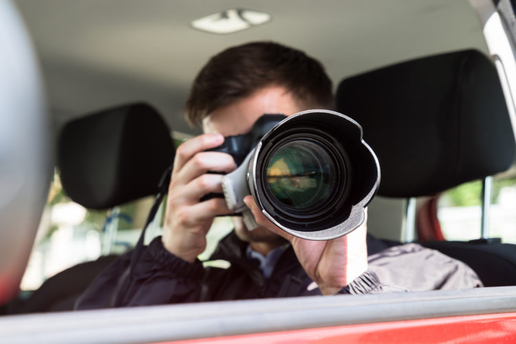 Detective privado haciendo foto desde coche