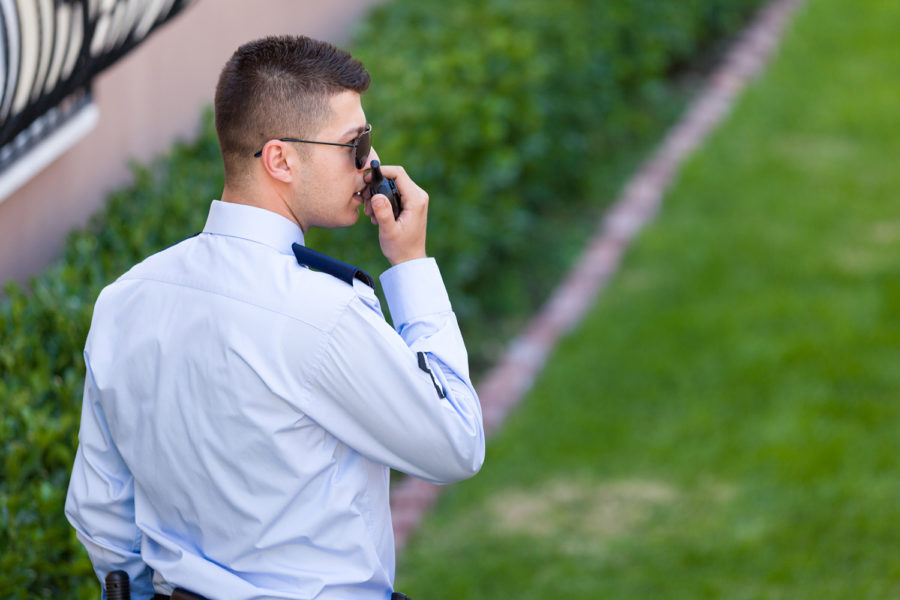 Vigilante de seguridad hablando por el walkie talkie