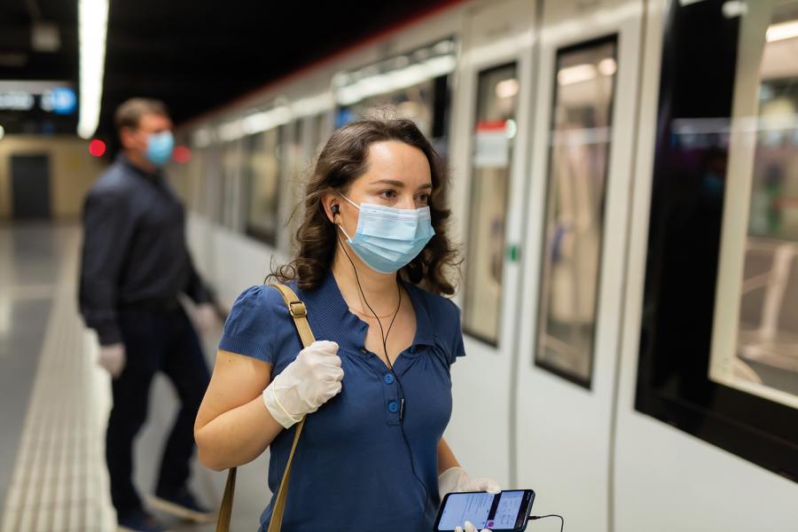 Una chica con mascarilla sube al metro.