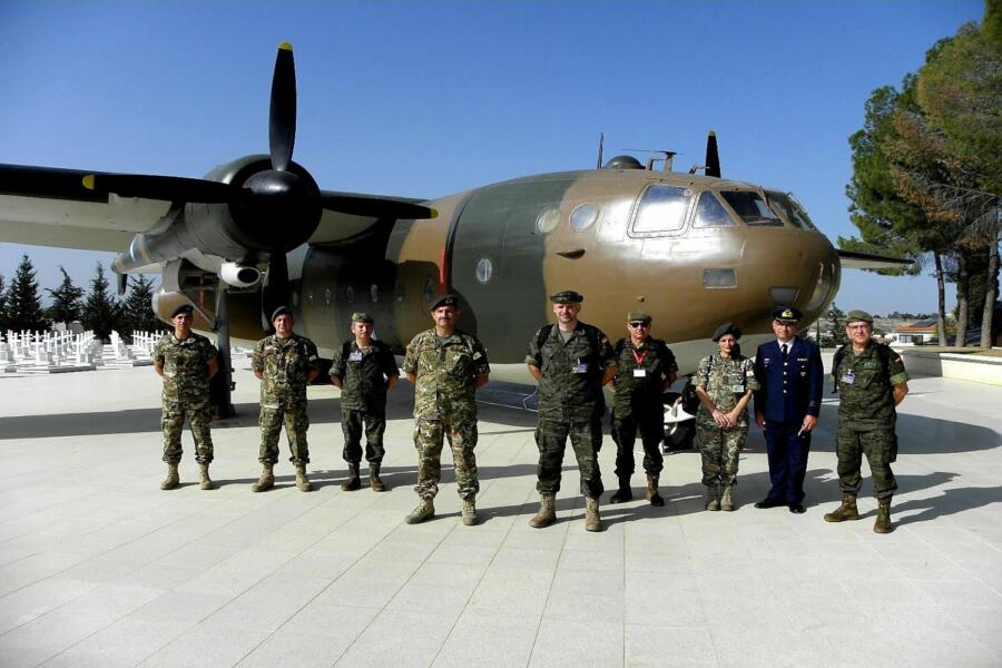 Nueve militares uniformados de la UVE en pie ante un avión de tonos marrones y negros.