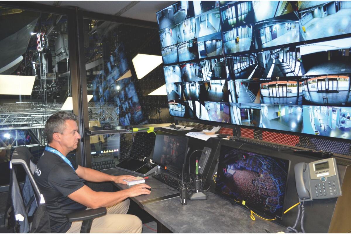 Juan Carlos Ruiz supervisando la seguridad en Movistar Arena desde la sala de control, rodeado de pantallas y sistemas de vigilancia.